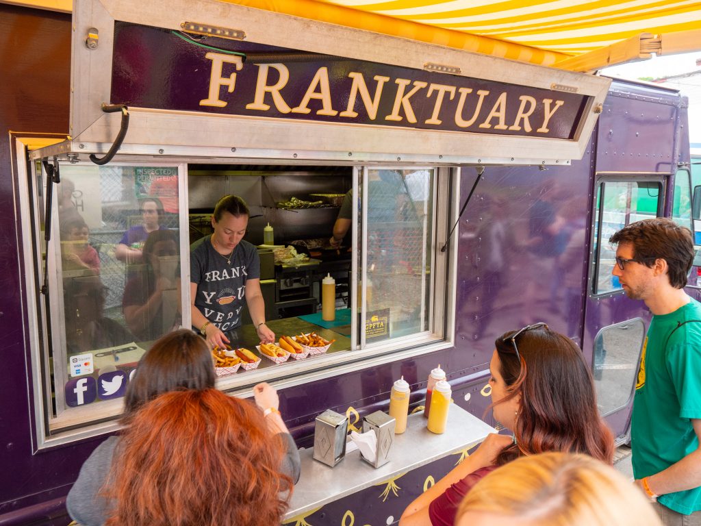 Franktuary Food Truck serving hot dogs at a festival.